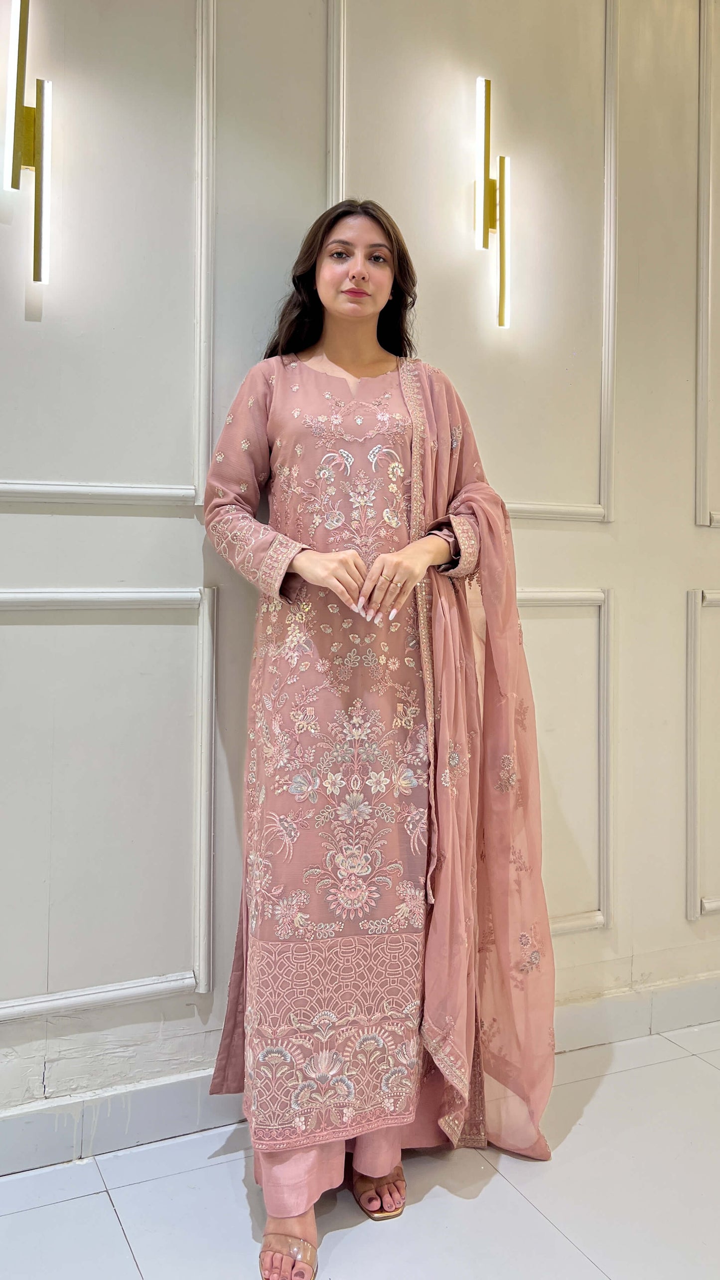 Woman wearing festive peach embroidered chiffon shalwar kameez suit