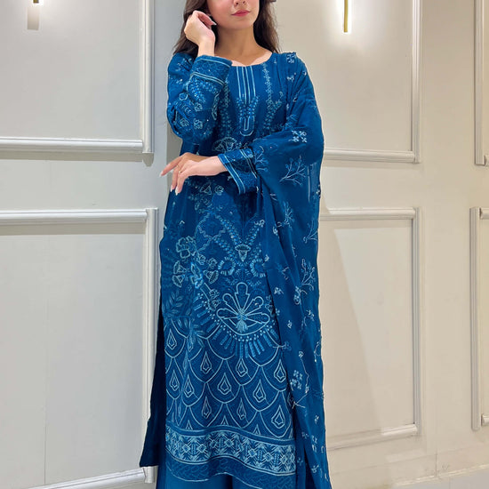 Woman in traditional pose wearing peacock blue embroidered outfit in video